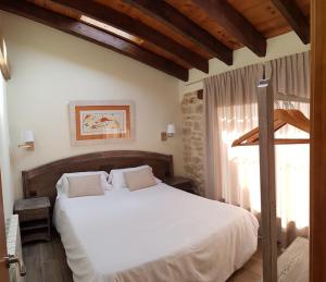 ein Schlafzimmer mit einem weißen Bett und einem Fenster in der Unterkunft Casa Gabaldá Apartamentos in Valderrobres