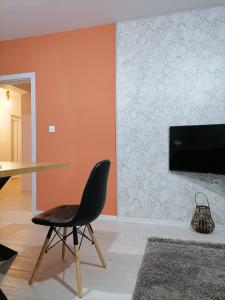 a dining room with a table and a black chair at Apartament Provence in Burgas