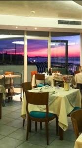 un restaurante con mesas y sillas y vistas en Hotel Majestic, en Gabicce Mare