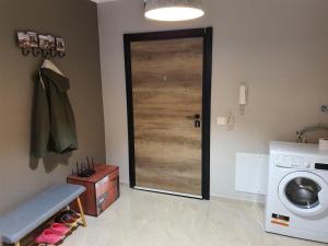 a laundry room with a door and a washing machine at GUEST SUITE Narodno horo in Sofia