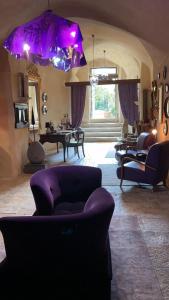 a living room with purple furniture and a purple umbrella at Maison d'Ax in Matera