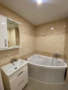 a bathroom with a white tub and a sink at Современная квартира в новом комплексе возле Днепра in Cherkasy