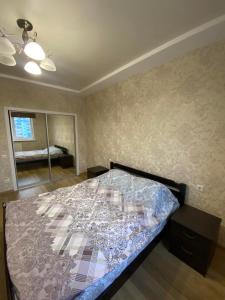 a bedroom with a large bed with a glass at Современная квартира в новом комплексе возле Днепра in Cherkasy