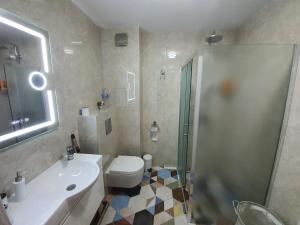 ein Badezimmer mit Toilette, Waschbecken und Dusche in der Unterkunft GUEST SUITE Narodno horo in Sofia + 6 Fotos