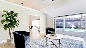 a living room with a table and chairs and a pool at Casa Cortez in Bradenton