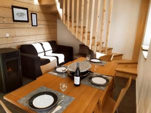 - Mesa de comedor con 2 copas y botella de vino en Gîte du Fourpéret-Parc Naturel du Haut-Jura, en Longevilles-Mont-dʼOr