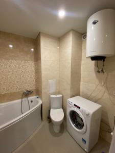 a bathroom with a toilet and a washing machine at Современная квартира в новом комплексе возле Днепра in Cherkasy +13 photos