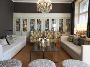 a living room with white furniture and a chandelier at Hotel Edelweiss in Davos