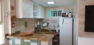 a kitchen with a refrigerator and a tv on top of it at Apto 518 - Golden Village Taperapuã in Porto Seguro