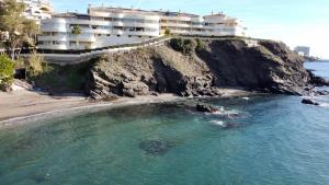 een gebouw op een klif naast een strand bij Costa Quebrada Residencial 1 in Benalmádena