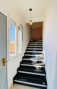 a hallway with black stairs with a window at Babyaccommodation Family Exclusive in Borgio Verezzi