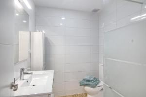Baño blanco con lavabo y aseo en EL Mojon Beach Apartment, en El Mojón