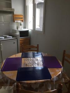 a kitchen with a wooden table with a blue plate on it at Appartement Cauterets in Cauterets