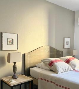 1 dormitorio con 1 cama y 1 mesa con lámpara en Un Coin De Luberon, en LʼIsle-sur-la-Sorgue