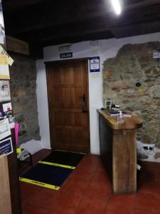 Pokój z drewnianymi drzwiami i kamienną ścianą w obiekcie Albergue el Castillo w mieście Villafranca del Bierzo