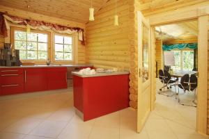 eine Küche mit einer roten Insel in einem Blockhaus in der Unterkunft Hotelanlage Country Lodge in Arnsberg