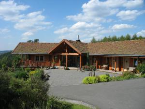Hotelanlage Country Lodge في أرنسبيرغ: كابينة خشبية مع شرفة وفناء
