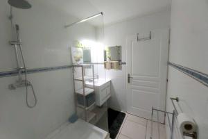 a white bathroom with a shower and a toilet at Appartement face à la marina du marin martinique in Le Marin