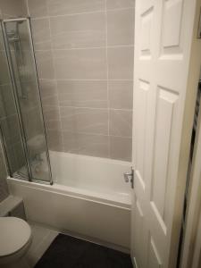 a white bathroom with a shower and a toilet at Wherstead Road House in Ipswich