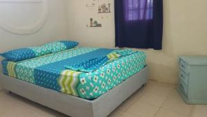 1 dormitorio con 1 cama con sábanas azules y puerta azul en Casita mi nuevo amanecer, en Santa Marta