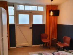 um quarto com uma porta e duas cadeiras em Damietta em Haarlem