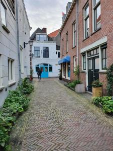 een persoon die door een geplaveide straat met gebouwen loopt bij Damietta in Haarlem