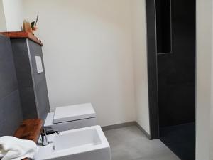 Un baño blanco con lavabo y ducha. en Casa Lassù., en Carano 2 fotos más