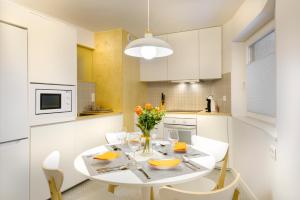 cocina blanca con mesa blanca y sillas en Loft Casa Berdon en Panticosa