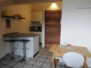 a kitchen with a counter and a table and stools at Casa Lassù. in Carano