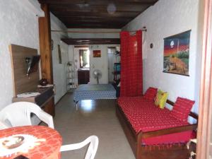 a living room with a red couch and a bed at Francais in La Paloma
