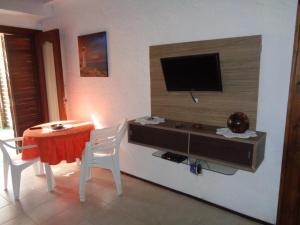 sala de estar con mesa y TV en la pared en Francais, en La Paloma
