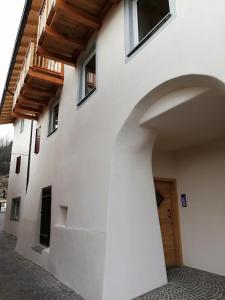 un edificio con un arco y una puerta de madera en Casa Lassù., en Carano