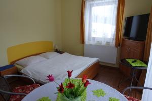 een slaapkamer met een bed en een tafel met bloemen erop bij Apartamenty u Ani in Kudowa-Zdrój