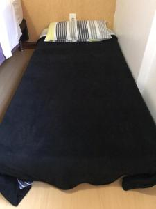 una manta negra sobre una cama en Duplex Borges De Medeiros, en Gramado