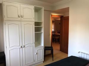 1 dormitorio con armarios blancos y 1 habitación con mesa en Duplex Borges De Medeiros, en Gramado