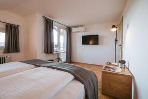 a bedroom with a bed and a tv on the wall at Bistro & Rooms pri Karlu - ex Hiša Budja in Maribor
