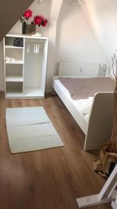 een slaapkamer met een wit bed en een witte kast bij City Apartment in Lörrach