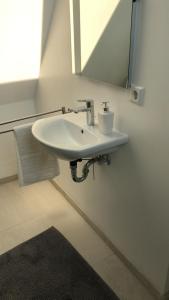 a white sink in a bathroom with a mirror at City Apartment in Lörrach