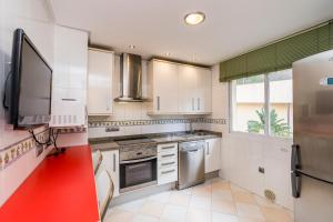 a kitchen with white cabinets and stainless steel appliances at Apartamento Estrella del Mar 100m de la playa 2 terrazas garage in Benalmádena