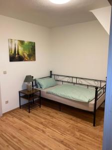 a bedroom with a bed and a side table at familienfreundliche Ferienwohnung Anna in Rollshausen