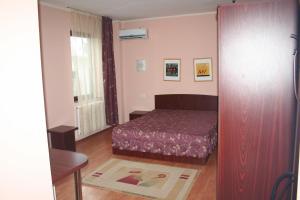 um pequeno quarto com uma cama e uma janela em Vila Montana em Constança