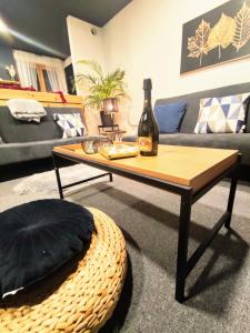 a living room with a table and a bottle of wine at Apartman Park Žilina & Free Parking in Žilina