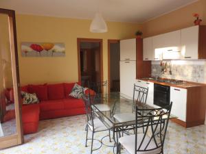 een keuken en een woonkamer met een tafel en stoelen bij Case Vacanze Residence Trinacria in Acireale