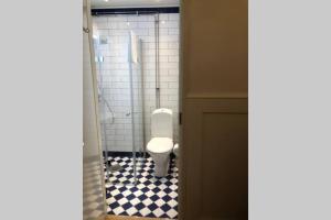 a bathroom with a toilet with a black and white tile floor at Captain’s Cabin Jakobstad Pietarsaari center in Pietarsaari