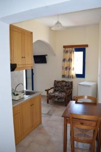 a kitchen and living room with a table and a couch at Mesohori studios in Sfakia