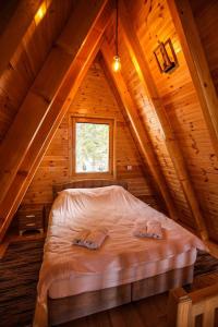 a bed in the attic of a log cabin at ZLATARSKA IDILA in Nova Varoš