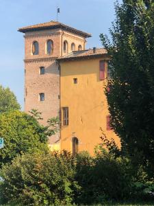 ein großes Gebäude mit einem Turm darüber in der Unterkunft Palazzo delle Biscie - Old Tower & Village in Molinella