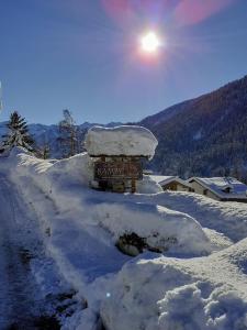 un cartel está cubierto de nieve en una montaña en Casa Bamby, en Cogolo
