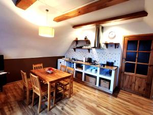 cocina con mesa de madera y sillas en una habitación en Maja 37 - niezależny apartament, en Janowice Wielkie