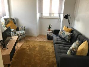 uma sala de estar com um sofá e duas cadeiras em Silvirhouse em Peniche